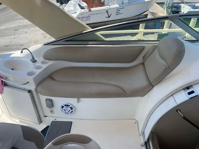 Slide: The Image of 2003 Larson 310 boat interior with beige seating and sink area. - 13