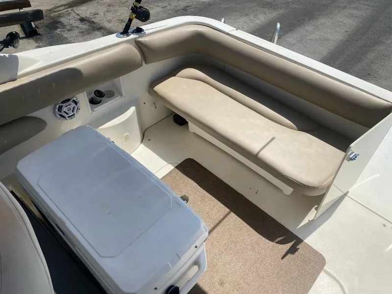 Slide: The Image of 2003 Larson 310 boat interior with beige seating and cooler. - 14