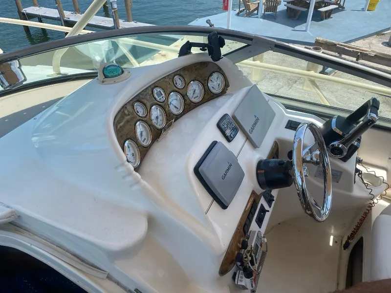 Slide: The Image of 2003 Larson 310 boat dashboard with Garmin navigation, steering wheel, and gauges. - 16