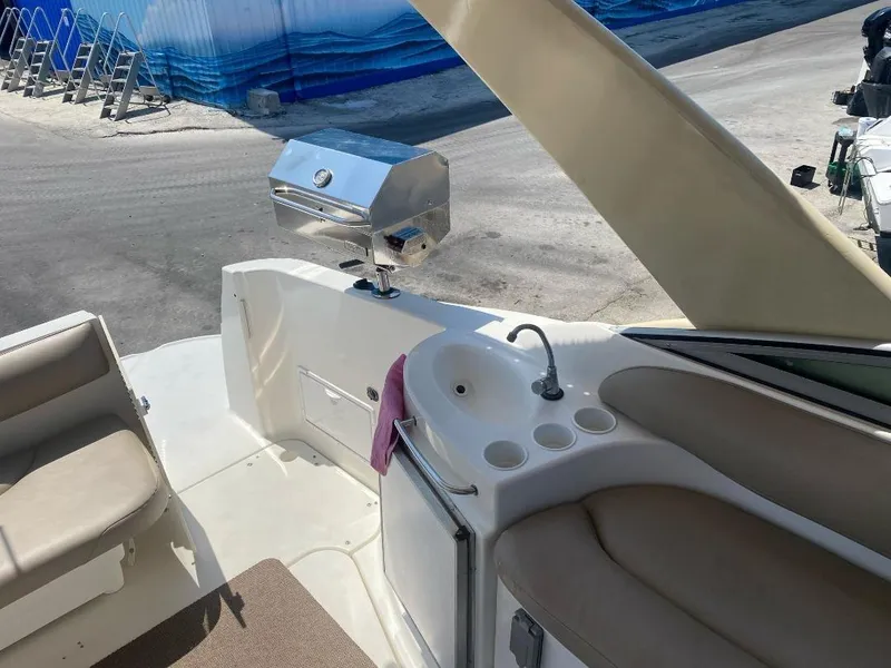 Slide: The Image of 2003 Larson 310 boat interior with sink and grill on deck. - 18