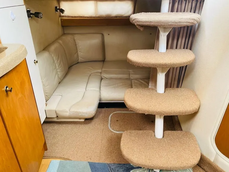 Slide: The Image of 2003 Larson 310 boat interior with beige seating and carpeted steps. - 4