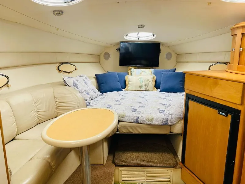 Slide: The Image of Cozy interior of 2003 Larson 310 boat with bed, seating, and TV. - 6