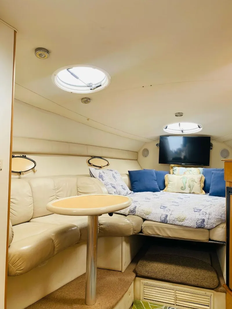 Slide: The Image of Interior of a 2003 Larson 310 boat with cozy seating and a bed. - 7