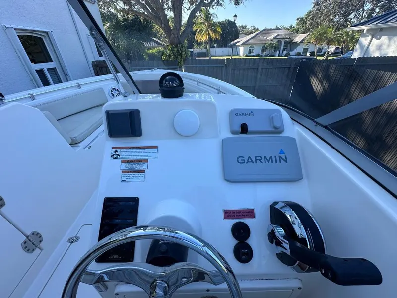 Slide: The Image of Cobia 220 DC 2022 boat dashboard with Garmin navigation system and steering wheel. - 14