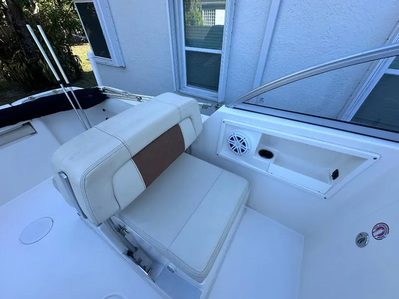 Slide: The Image of 2022 Cobia 220 DC boat interior with white seating and speaker. - 21