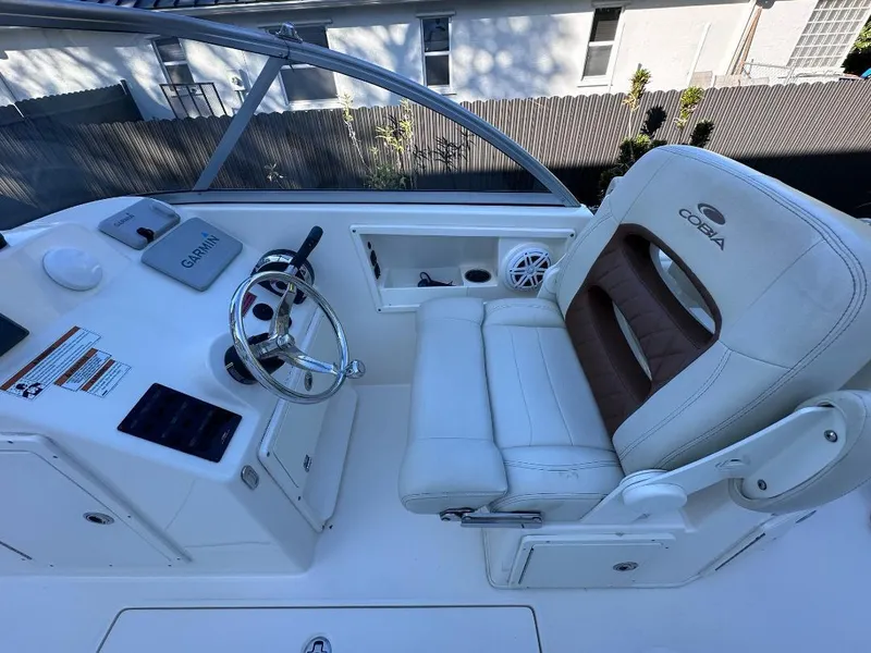Slide: The Image of 2022 Cobia 220 DC boat cockpit with Garmin system and cushioned seating. - 22