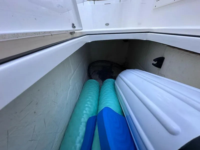 Slide: The Image of Storage compartment in 2022 Cobia 220 DC boat with fenders and mats. - 24
