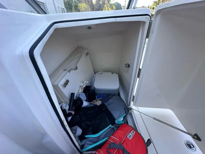 Slide: The Image of Storage compartment of 2022 Cobia 220 DC boat with gear and cooler. - 9