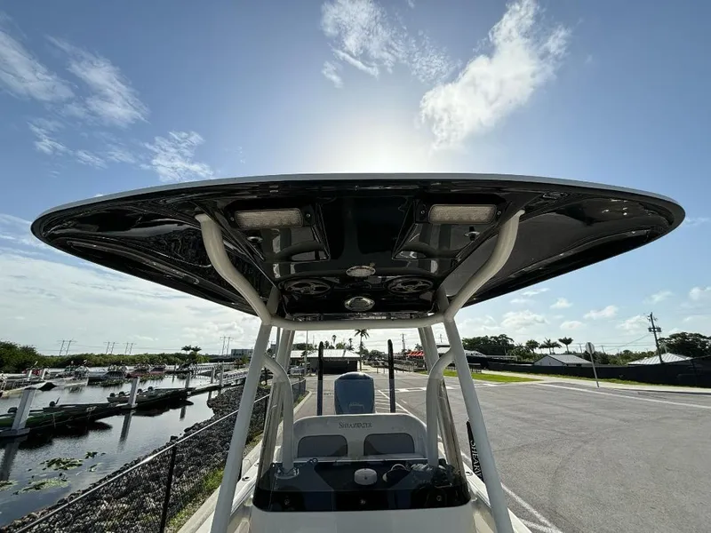 Slide: The Image of 2014 ShearWater 25LTZ boat with T-top, docked under clear blue sky. - 10