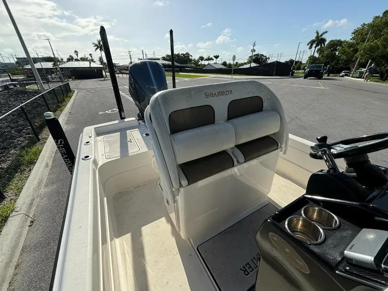 Slide: The Image of 2014 ShearWater 25LTZ boat interior with seating and console, parked on a sunny day. - 12