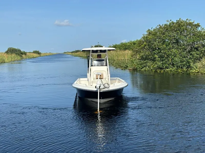 Slide: The Image of 2014 ShearWater 25LTZ boat on a calm waterway, surrounded by lush greenery. - 4