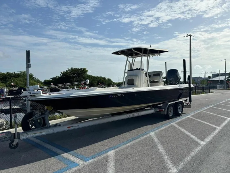 Slide: The Image of 2014 ShearWater 25LTZ boat on trailer in parking lot under blue sky. - 5