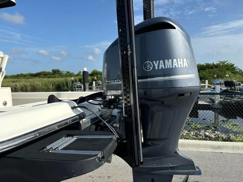 Slide: The Image of 2014 ShearWater 25LTZ boat with Yamaha outboard motor, docked under clear blue sky. - 6