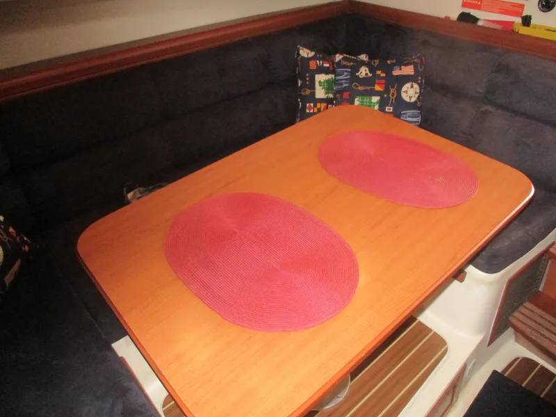 Slide: The Image of 2007 Mainship Pilot 34 Sedan interior with wooden table and red placemats. - 10