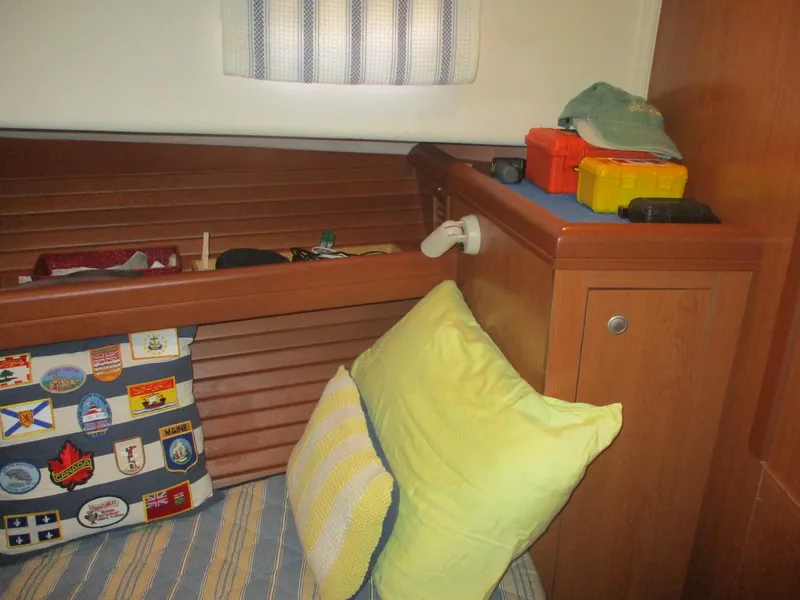 Slide: The Image of 2007 Mainship Pilot 34 Sedan cabin with cushions, storage, and nautical decor. - 16