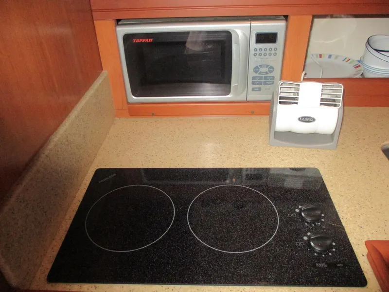 Slide: The Image of 2007 Mainship Pilot 34 Sedan kitchen with stovetop and microwave. - 19