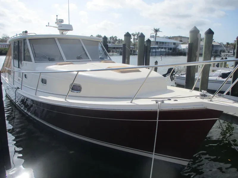Slide: The Image of 2007 Mainship Pilot 34 Sedan docked at marina, showcasing sleek design and spacious cabin. - 2