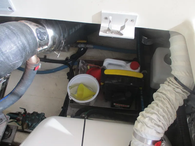 Slide: The Image of Engine compartment of 2007 Mainship Pilot 34 Sedan with hoses and maintenance supplies. - 26