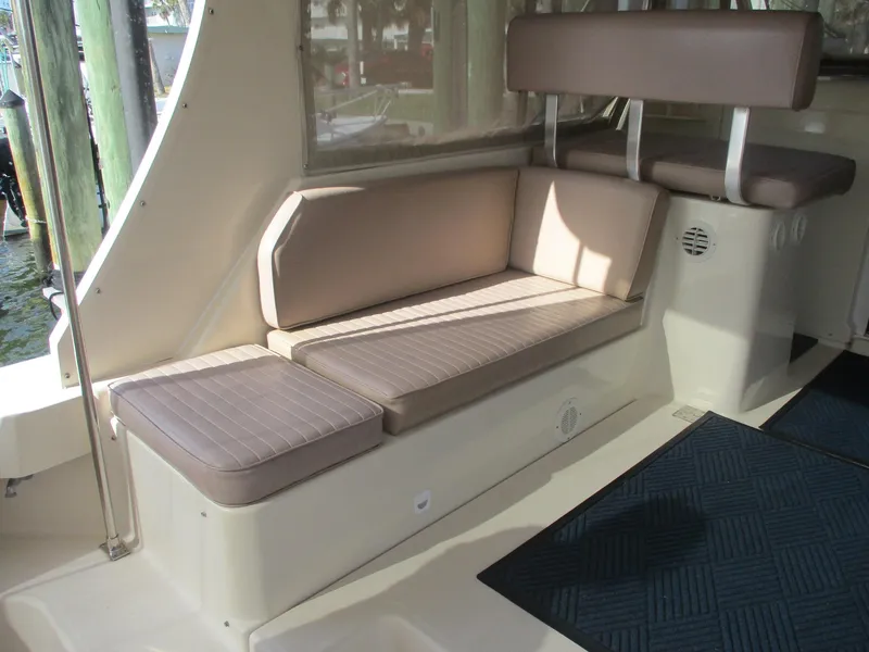 Slide: The Image of 2007 Mainship Pilot 34 Sedan interior seating with beige cushions and blue carpet. - 29