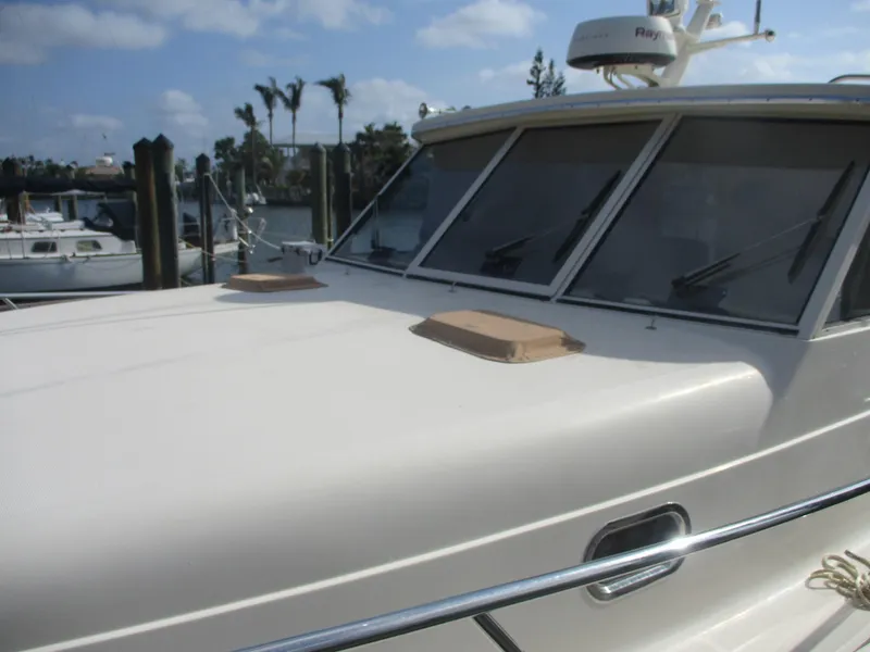 Slide: The Image of 2007 Mainship Pilot 34 Sedan boat with sleek design and large windows, docked at marina. - 33