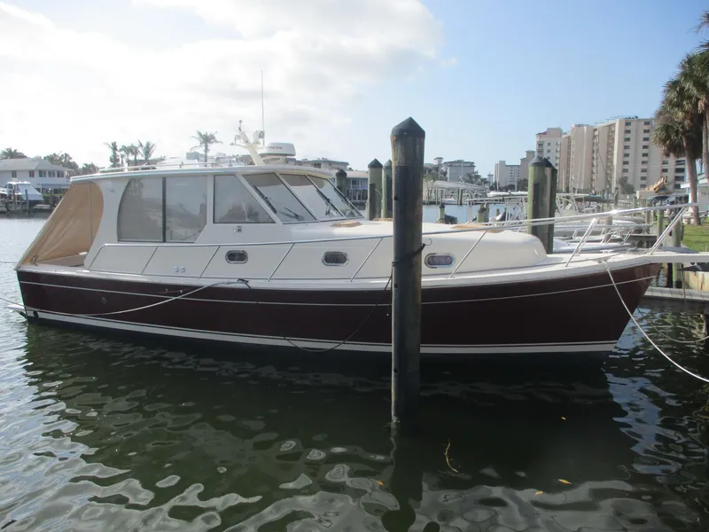Slide: The Image of 2007 Mainship Pilot 34 Sedan docked in a marina, featuring a sleek design and spacious cabin. - 35