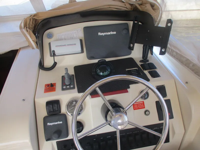 Slide: The Image of 2007 Mainship Pilot 34 Sedan helm with Raymarine electronics and steering wheel. - 4