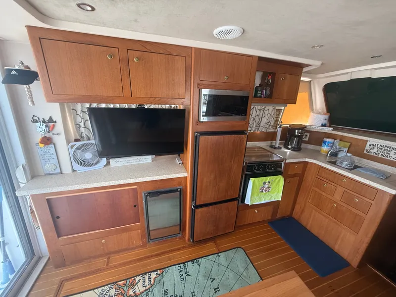 Slide: The Image of Mainship 390 Trawler 2000 interior kitchen with wooden cabinets, appliances, and countertop. - 10