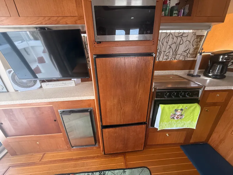 Slide: The Image of Interior of 2000 Mainship 390 Trawler with kitchen appliances and wooden cabinetry. - 12