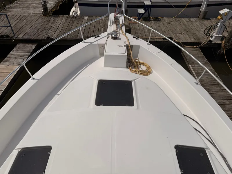 Slide: The Image of 2000 Mainship 390 Trawler bow view at dock, featuring deck and railing. - 18