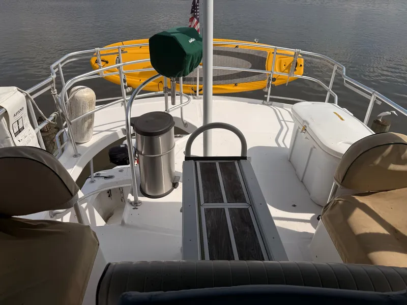 Slide: The Image of 2000 Mainship 390 Trawler deck with seating, storage, and a yellow kayak. - 19