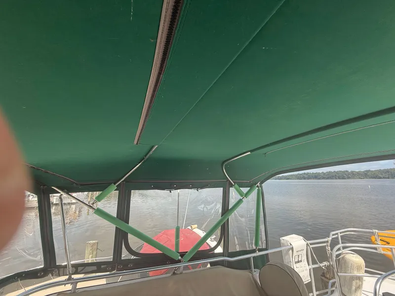 Slide: The Image of Interior view of 2000 Mainship 390 Trawler with green canopy and waterfront background. - 23