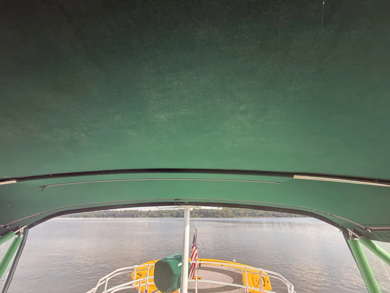 Slide: The Image of View from Mainship 390 Trawler, 2000 model, under green canopy on calm water. - 24