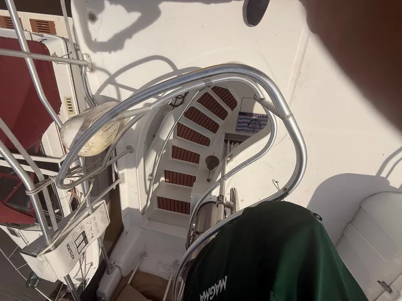 Slide: The Image of 2000 Mainship 390 Trawler deck with metal railings and steps, featuring nautical equipment. - 26