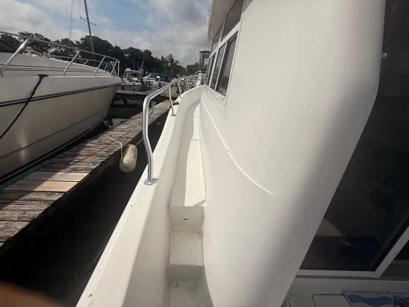Slide: The Image of Side view of a 2000 Mainship 390 Trawler docked at a marina. - 33
