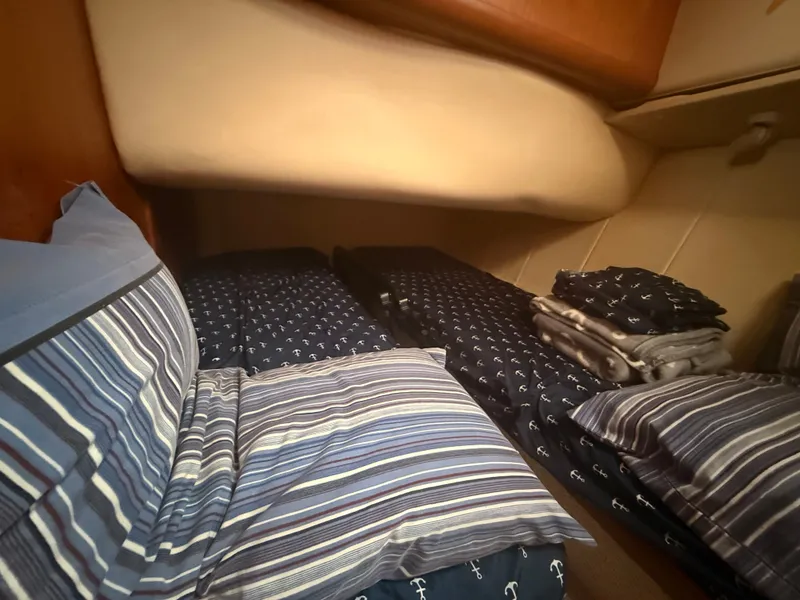 Slide: The Image of Cozy cabin interior of 2000 Mainship 390 Trawler with striped bedding and anchor patterns. - 37