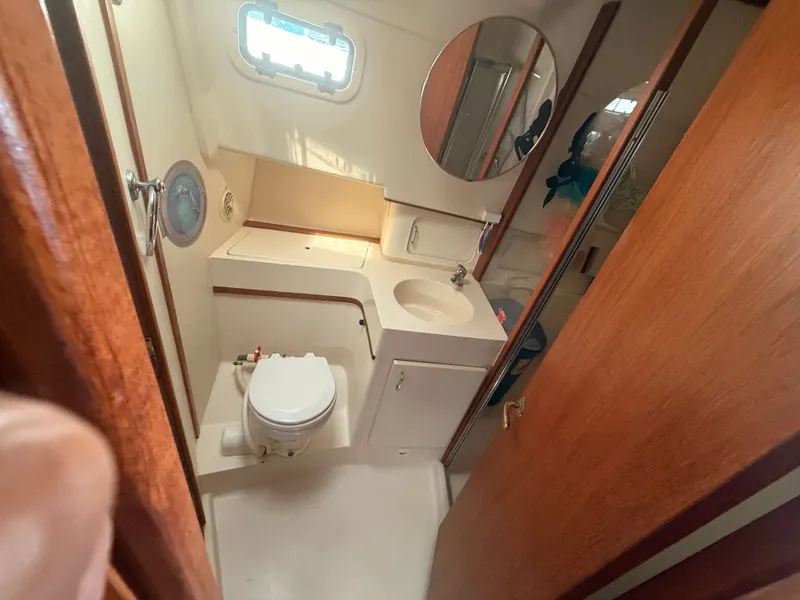 Slide: The Image of 2000 Mainship 390 Trawler bathroom with sink, toilet, and mirror. - 41