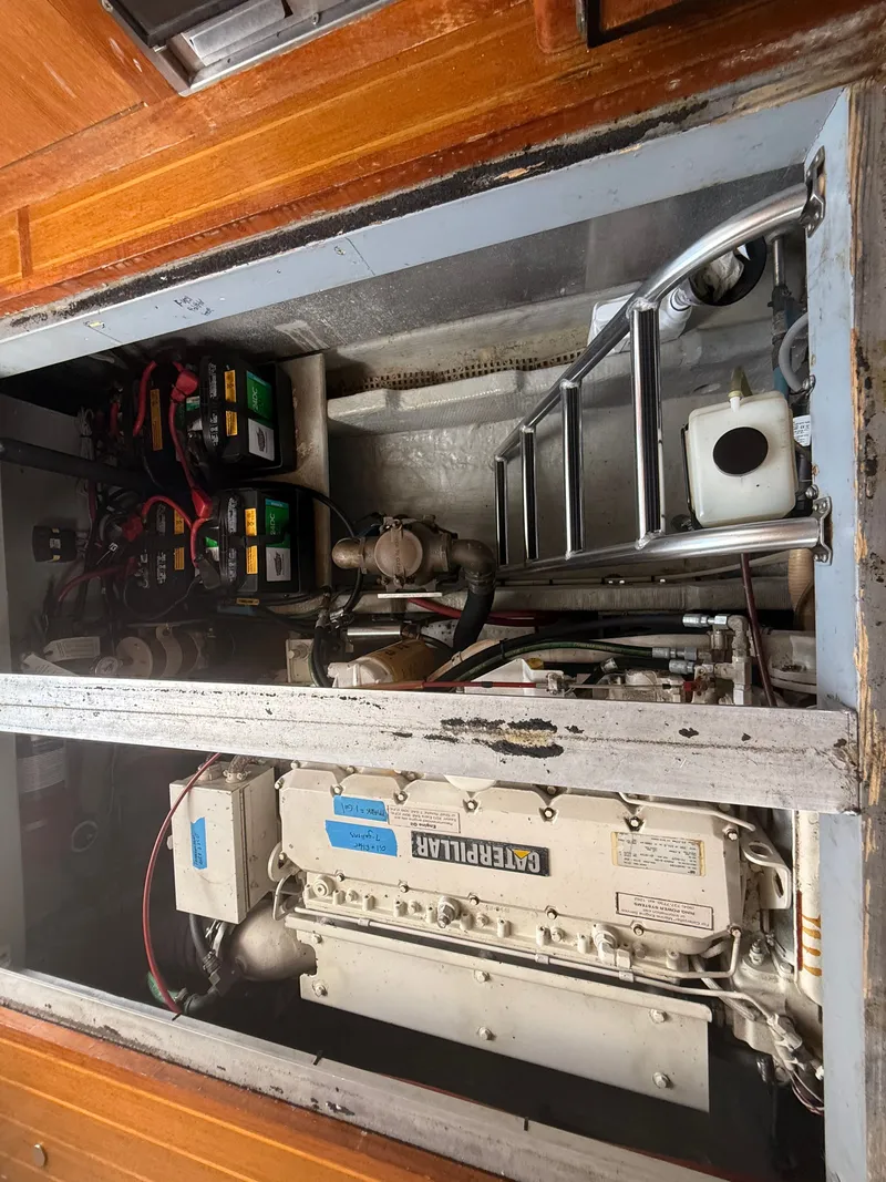 Slide: The Image of Engine compartment of a 2000 Mainship 390 Trawler, featuring a Caterpillar engine and battery setup. - 42