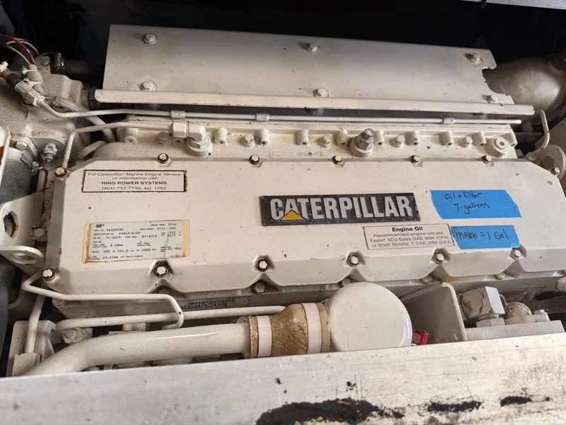 Slide: The Image of Caterpillar marine engine in a 2000 Mainship 390 Trawler, showing service details and oil specifications. - 45