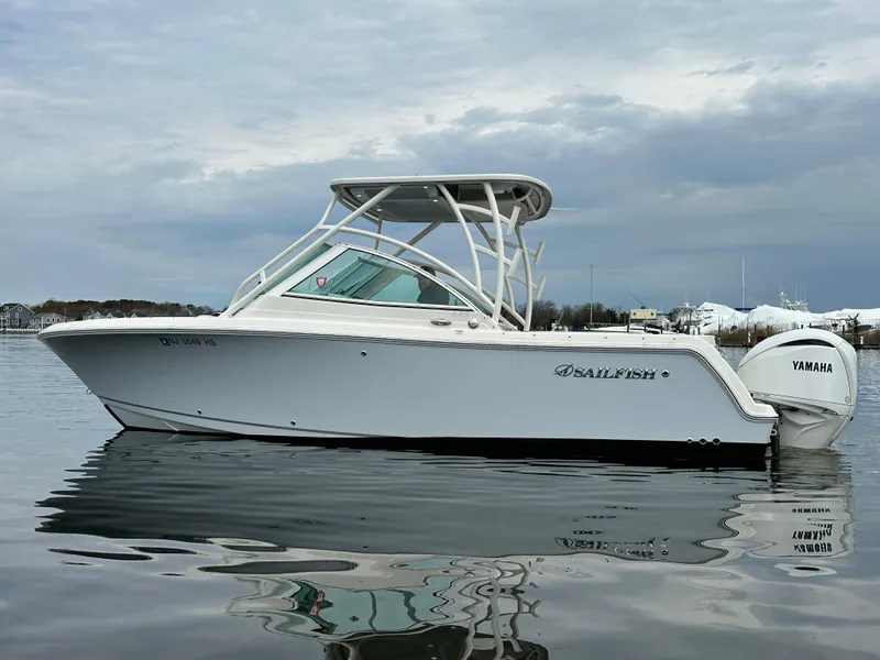 Slide: The Image of 2023 Sailfish 245 DC boat on calm water, featuring Yamaha engine. - 0