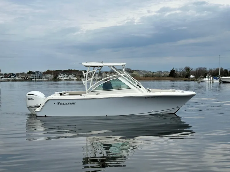 Slide: The Image of 2023 Sailfish 245 DC boat on calm water under cloudy sky. - 1