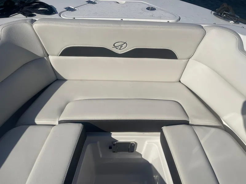 Slide: The Image of 2023 Sailfish 245 DC boat interior seating, featuring white and gray upholstery. - 13
