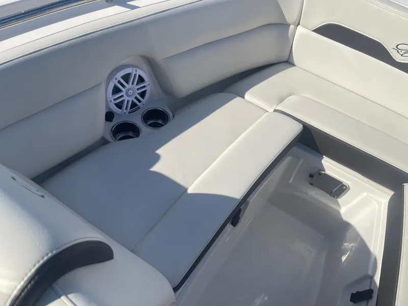 Slide: The Image of 2023 Sailfish 245 DC boat interior with cushioned seating and built-in cup holders. - 14