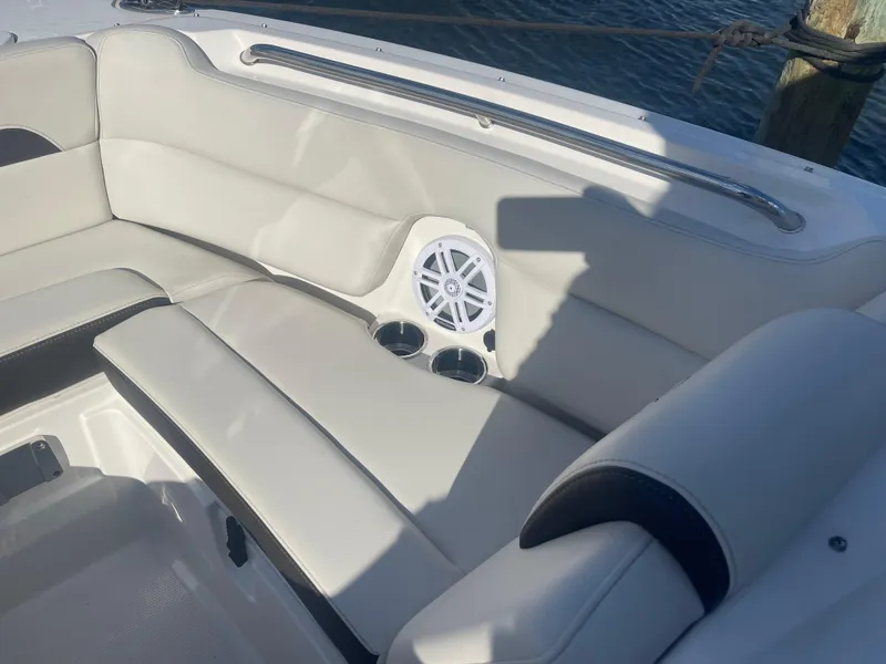 Slide: The Image of 2023 Sailfish 245 DC boat interior with white seating, speaker, and cup holders. - 15