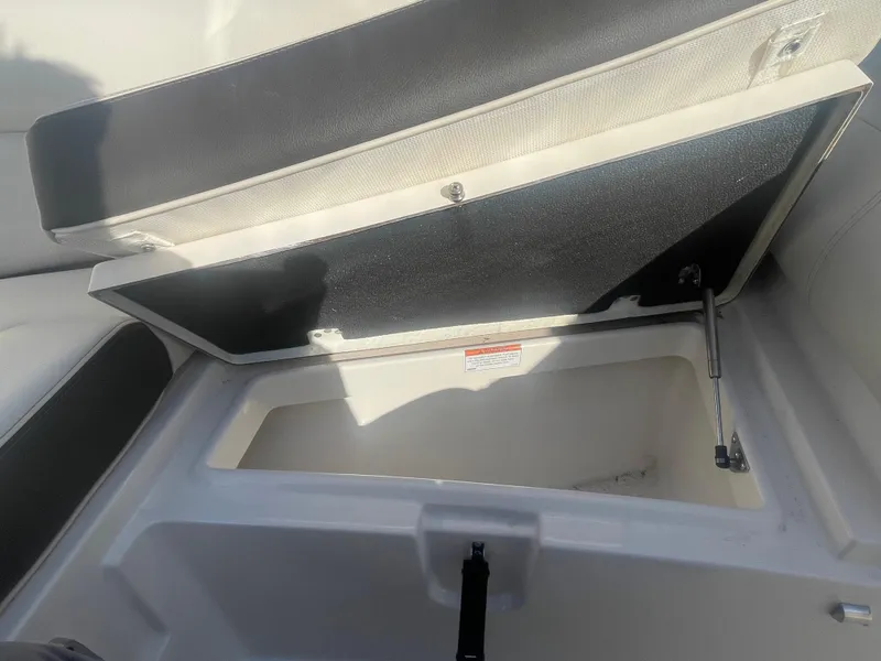 Slide: The Image of 2023 Sailfish 245 DC boat storage compartment with open lid, showcasing interior space. - 17