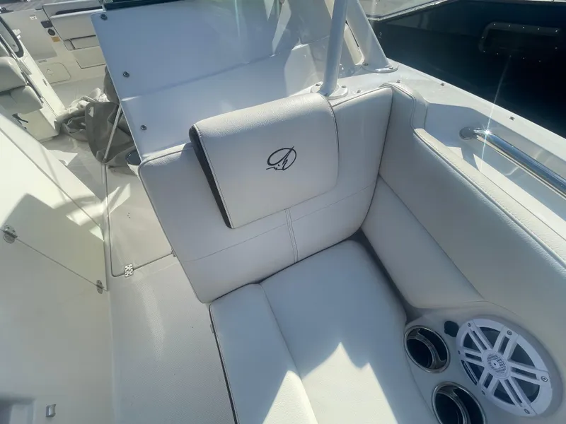Slide: The Image of 2023 Sailfish 245 DC boat interior with white seating and built-in speakers. - 19