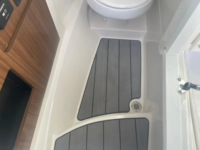 Slide: The Image of 2023 Sailfish 245 DC boat interior with wood paneling and marine toilet. - 25