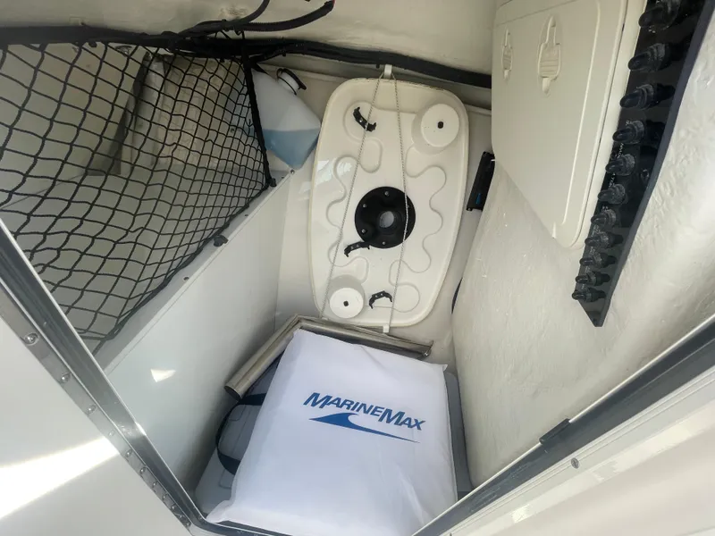 Slide: The Image of 2023 Sailfish 245 DC boat interior storage compartment with MarineMax towel and netting. - 26