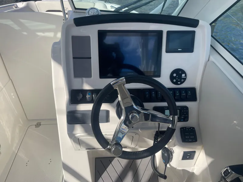 Slide: The Image of 2023 Sailfish 245 DC boat dashboard with steering wheel and control panel. - 27