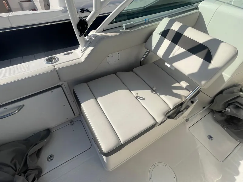 Slide: The Image of 2023 Sailfish 245 DC boat interior with cushioned seating and storage compartments. - 31