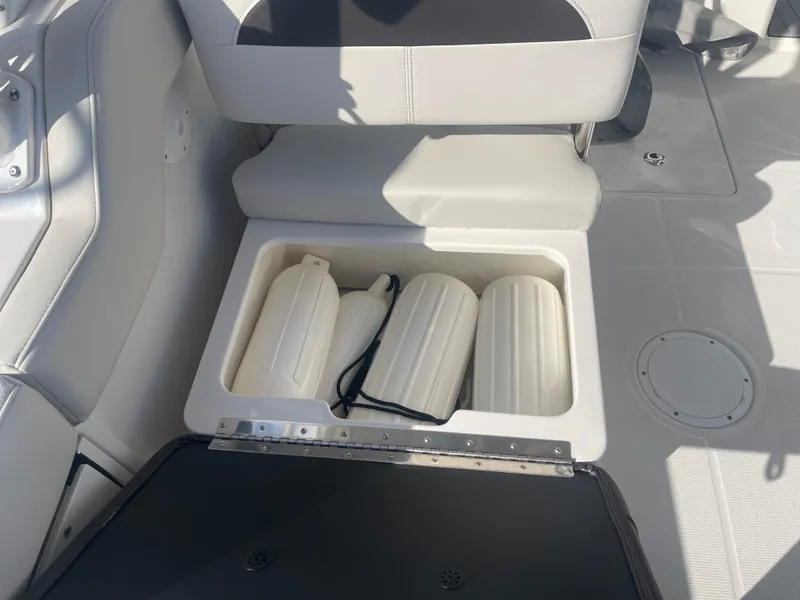 Slide: The Image of 2023 Sailfish 245 DC boat seat storage with fenders and accessories. - 33